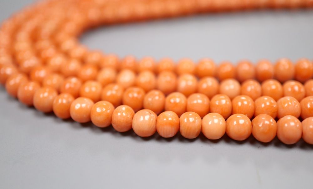 A single strand coral bead necklace, with yellow metal spacer, 197cm, gross weight 56 grams,